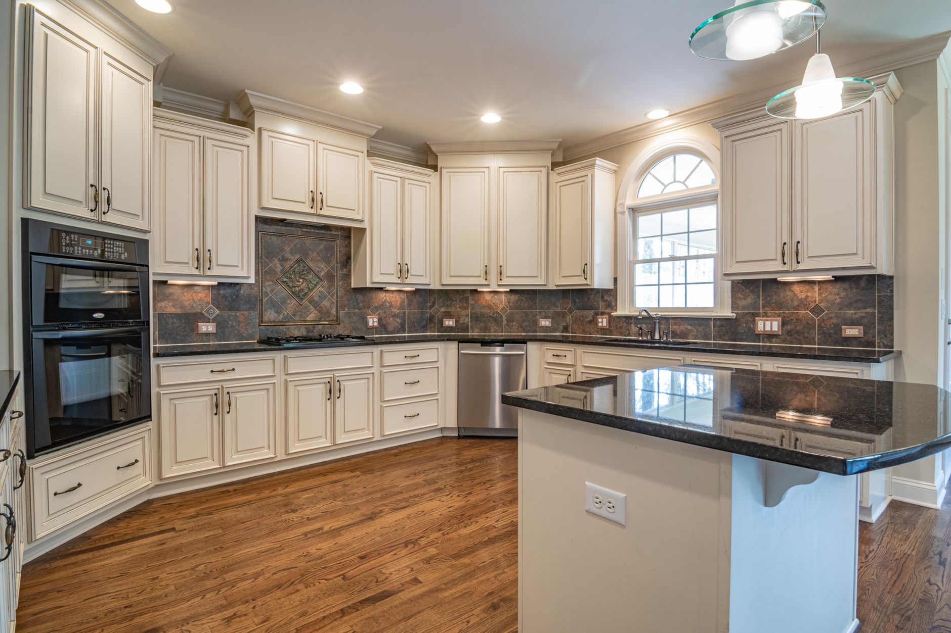 A spacious, modern kitchen with white cabinetry and a sleek black countertop, perfect for culinary in Buncombe County, NC