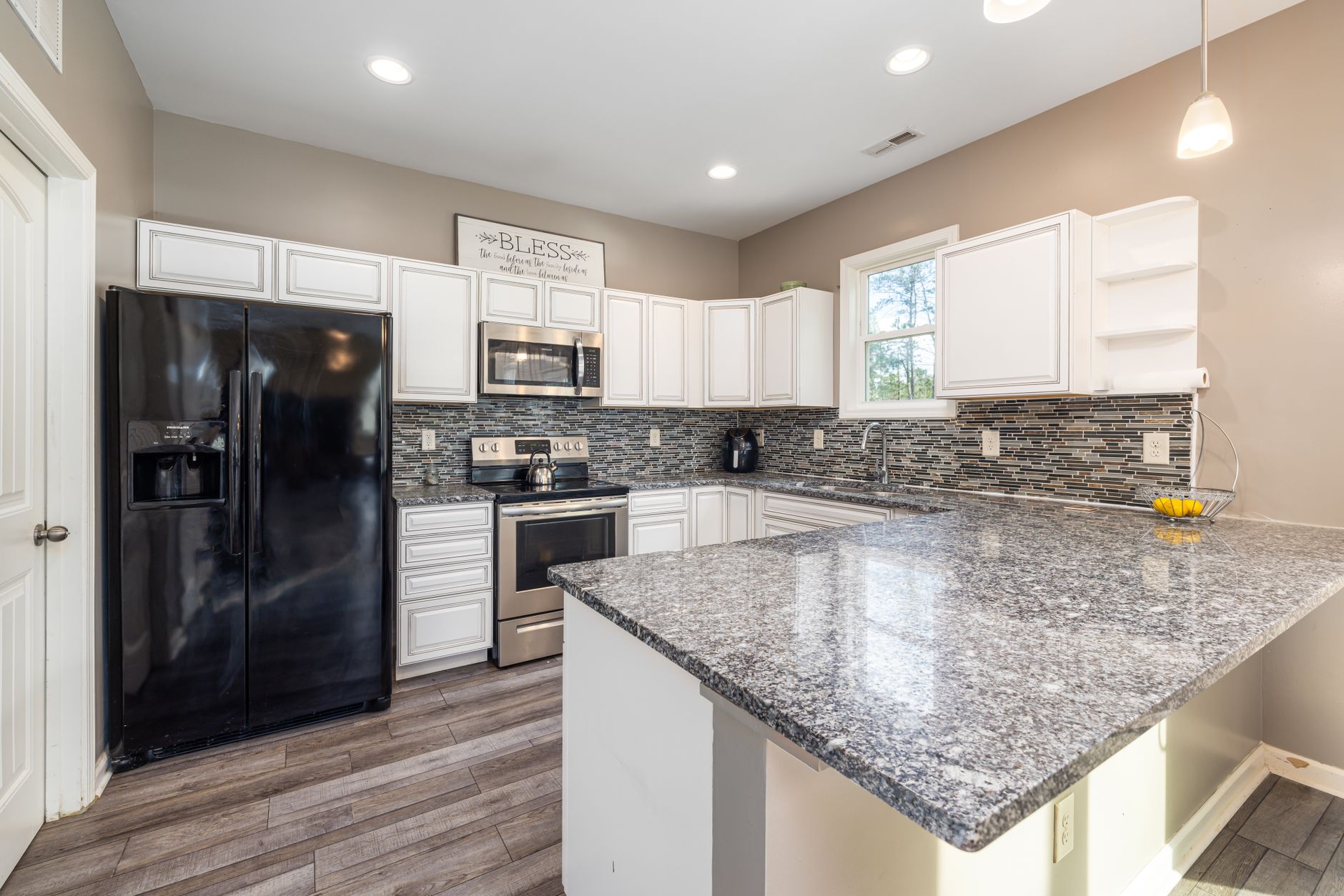 Elegant kitchen with sleek granite countertops and black appliances, perfect for modern living in Buncombe County, NC